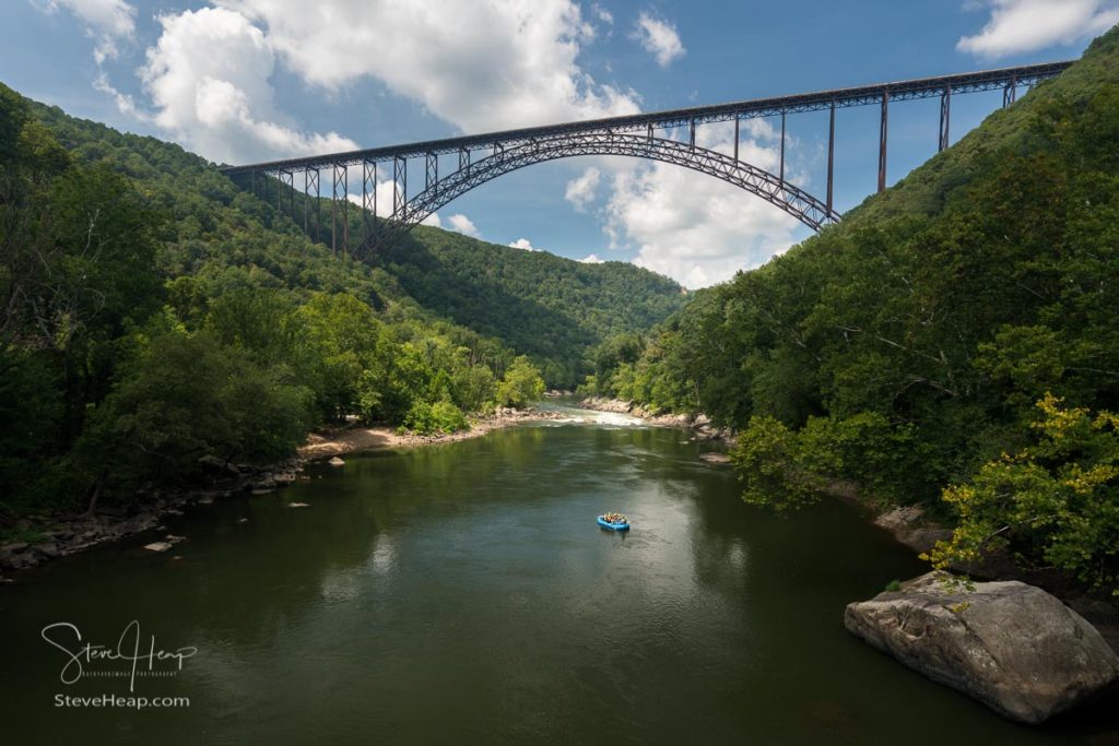 Rafters float towards the rapids under the high arched New River Gorge bridge in West Virginia. What I like about this image in particular is the subtle lighting. It is generally quite dark although the destination (the rapids) are more brightly lit with the sun, and the raft in blue is quite sharp and clear (of course that got a little extra work in Lightroom!)