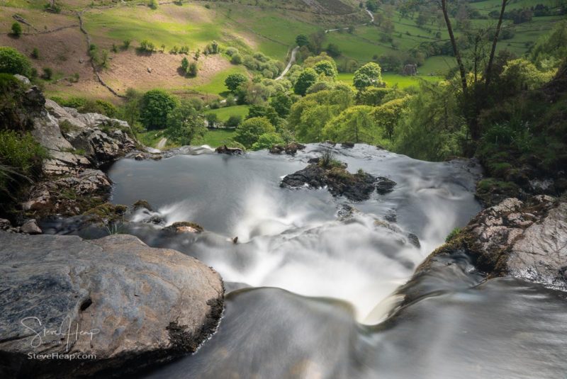 Smooth blurred motion stream falls into valley from the top of the Pistyll Rhaeadr waterfall in Wales