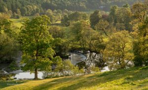 River Dee flows over the weir that feeds the Llangollen canal at Horseshoe falls on calm evening