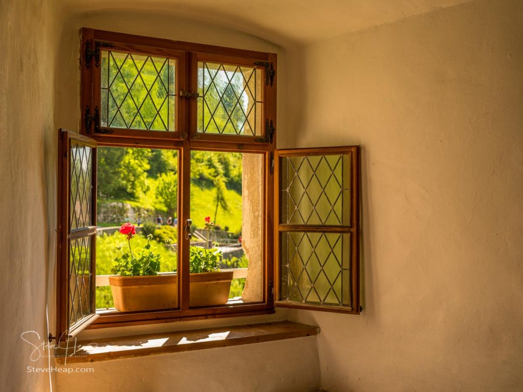 Simple window with flower box in solid stone wall in old castle