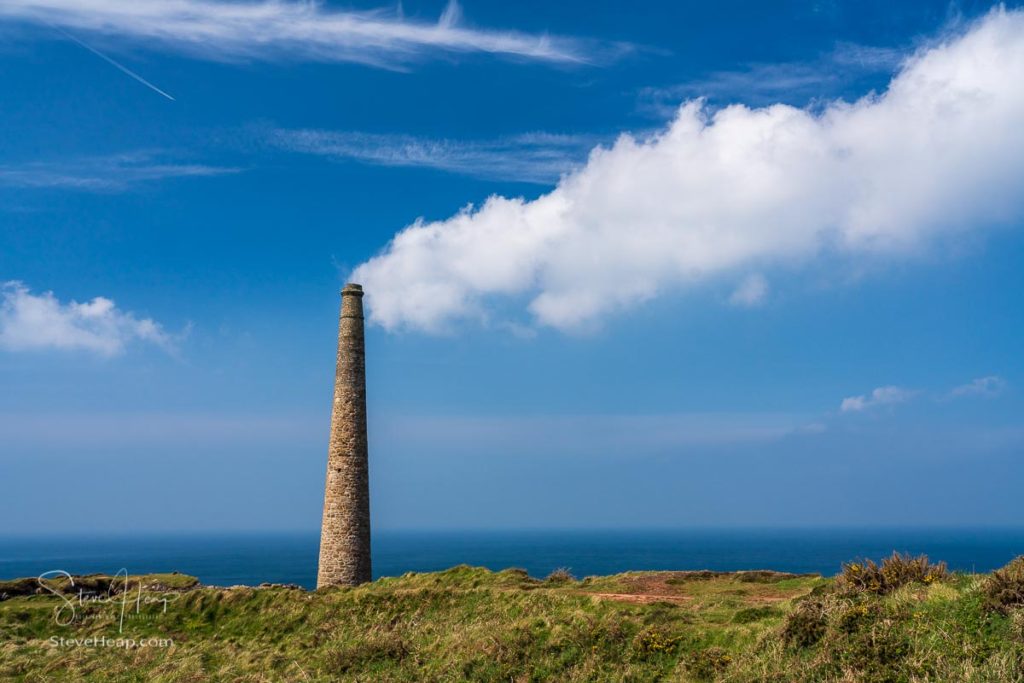 Historic remains of the chimney stack with clouds at Botallack tin mine in Cornwall