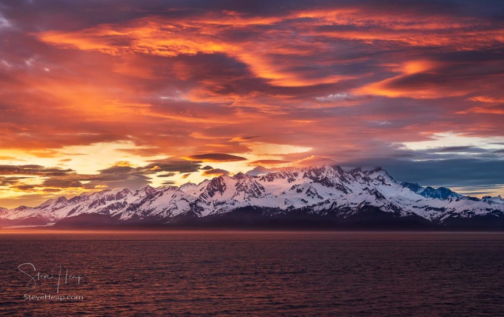 Dramatic sunset over the mountains of Alaska as the sun finally hits the horizon