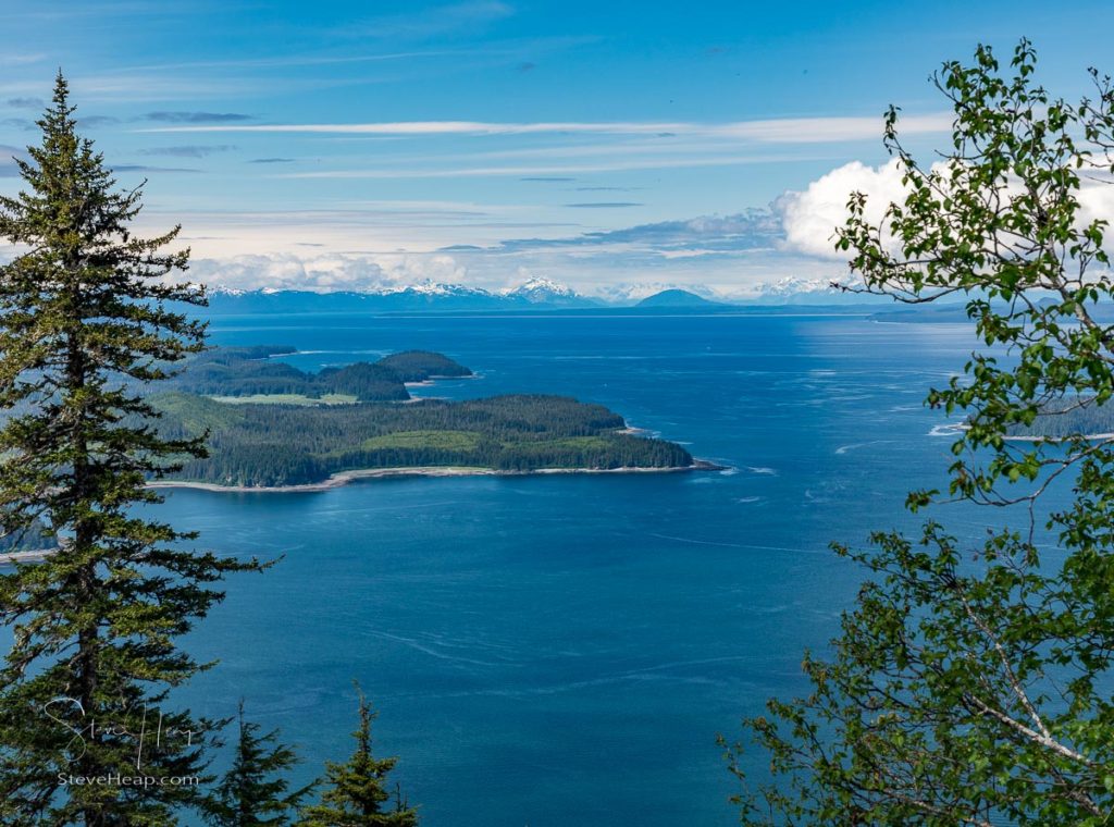 View through trees of the bay and mountains at Icy Strait Point near Hoonah in Alaska. Prints available in my online store