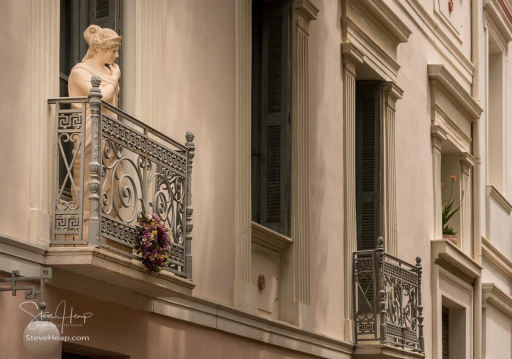 Statue on a wrought iron balcony in ancient district or neighborhood of Plaka in Athens by the Acropolis. Prints in my online store