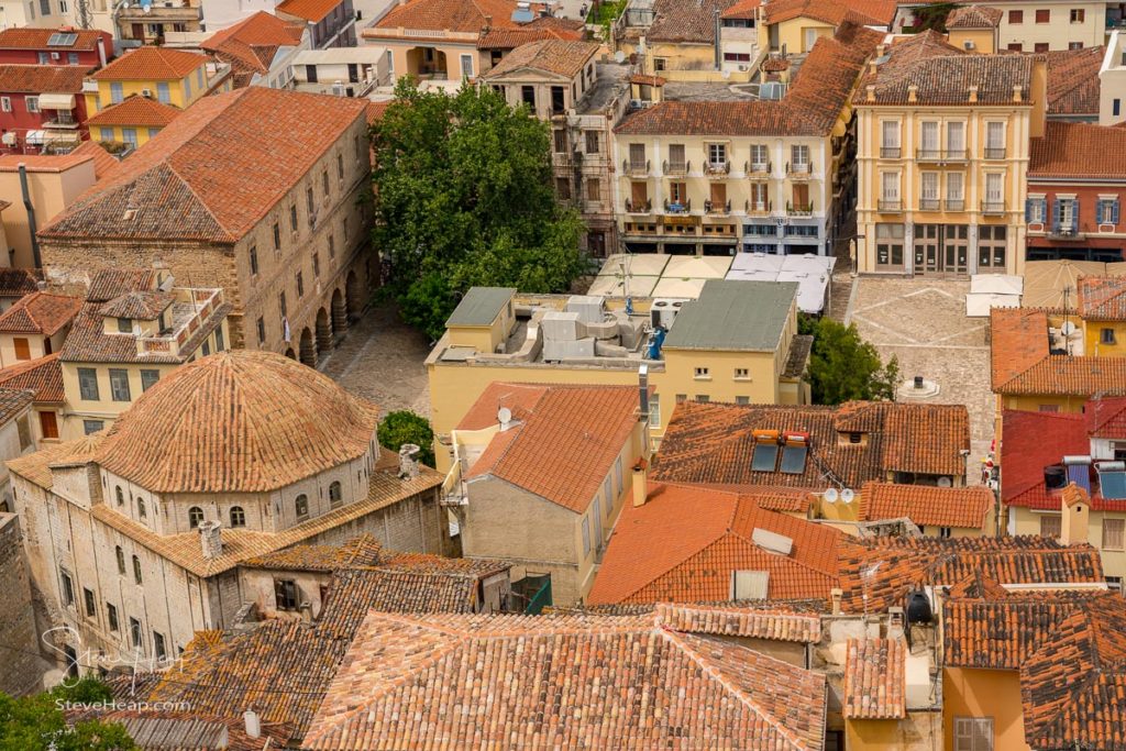 NAFPLIO, GREECE - 15 MAY 2019: Aerial view over the old tiled roofs to square in the city of Nafplio in Greece