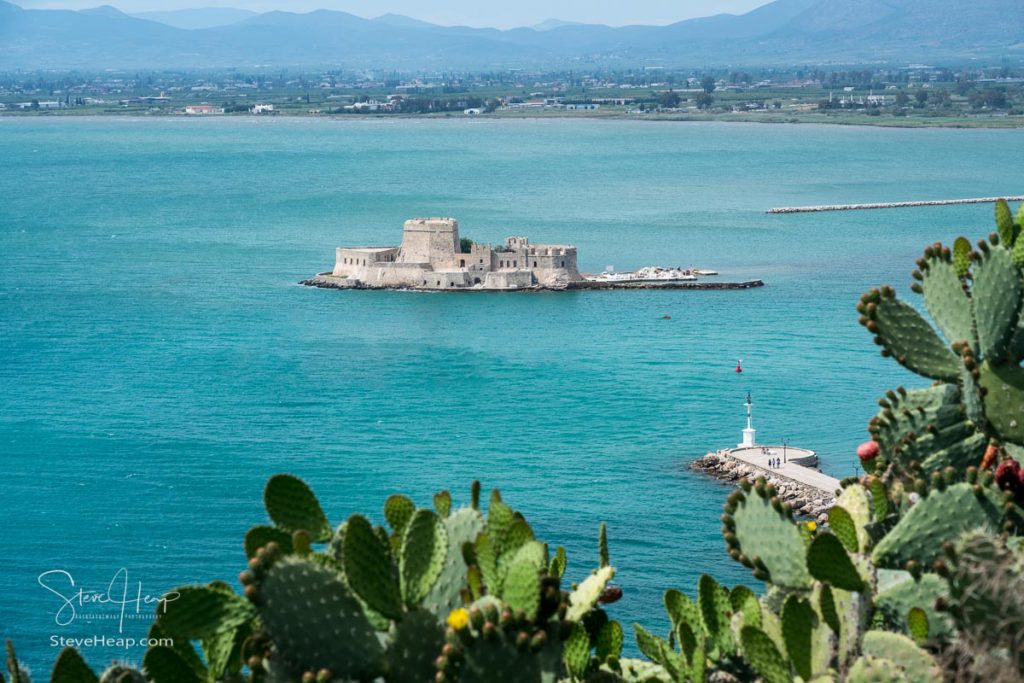 Cactus plants frame the old venetian castle of Bourtzi in the harbor of Nafplio