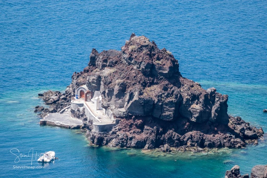 Small island of Saint Nicholas below village of Oia on Santorini