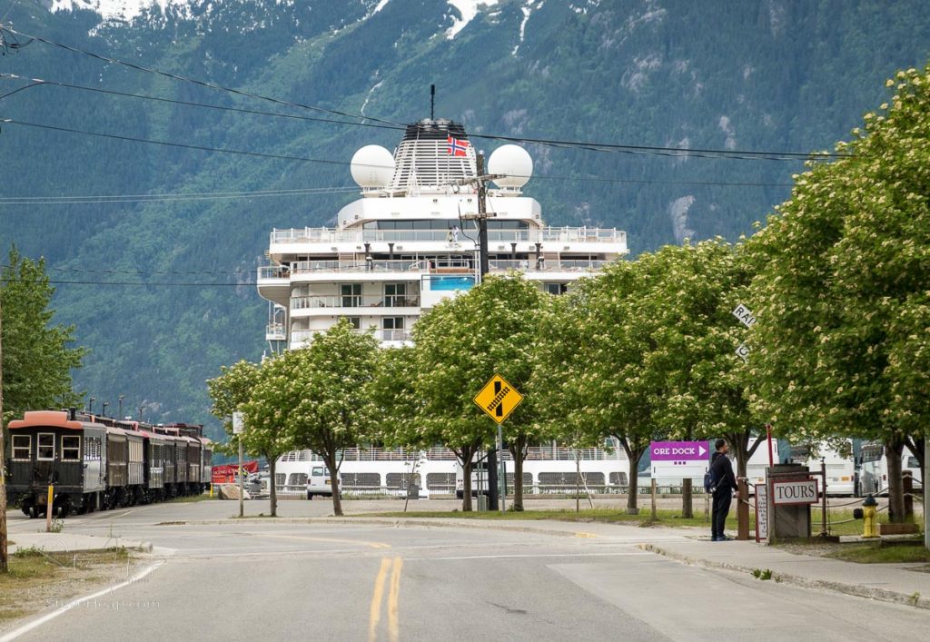 Skagway, AK - 6 June 2022: White pass tourist train by Viking Orion cruise ship in dock