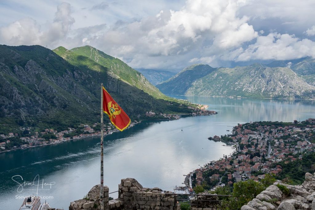 Aerial view of Dobrota and Kotor from hike to Fortress with Montenegro national flag