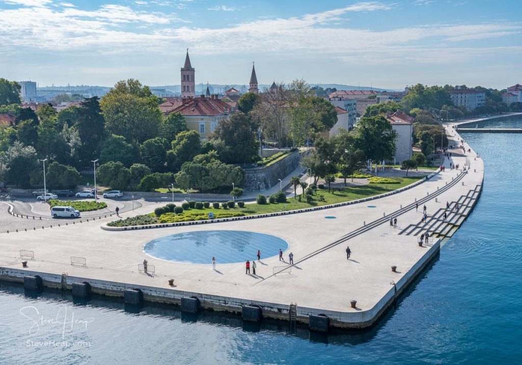 People on the promenade watch the arrival of cruise ship in the port of Zadar