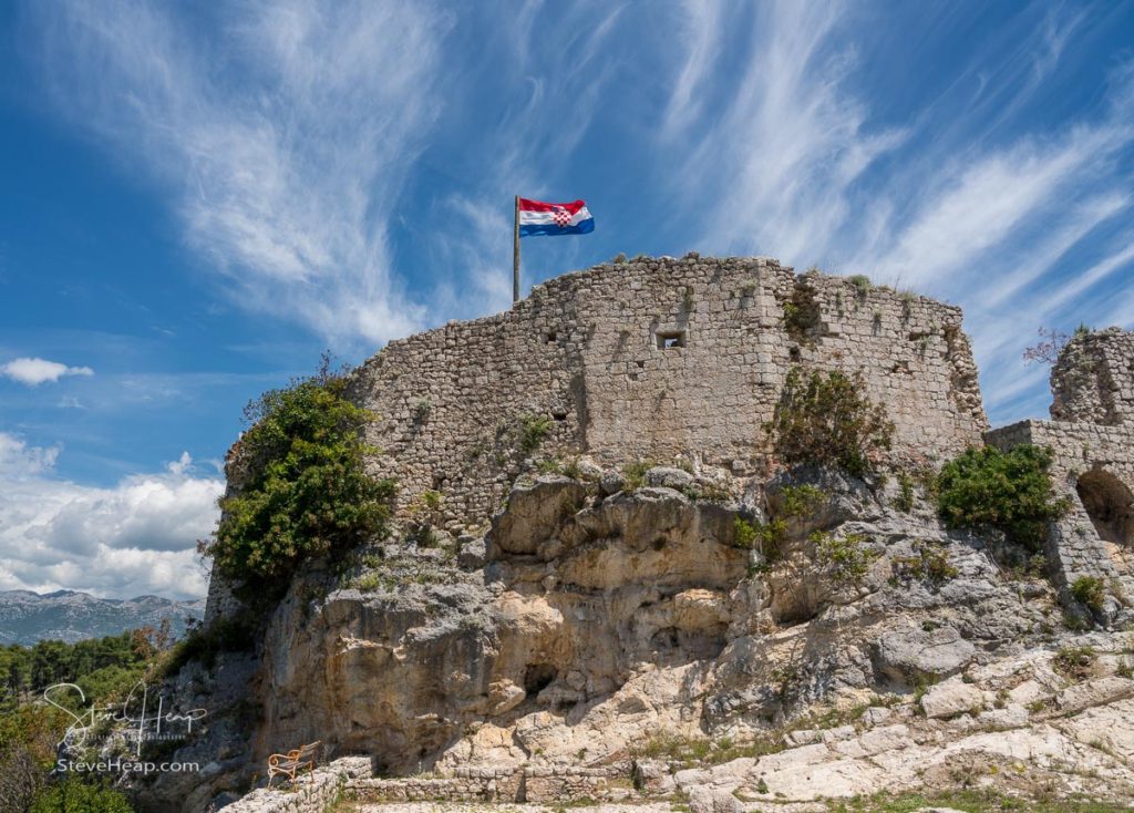 Croatian flag flies above ruins of old Venetian fort above the coastal town of Novigrad in Croatia