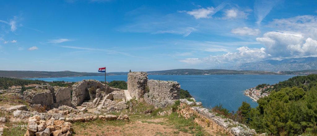 Croatian flag flies above ruins of old Venetian fort above the coastal town of Novigrad in Croatia