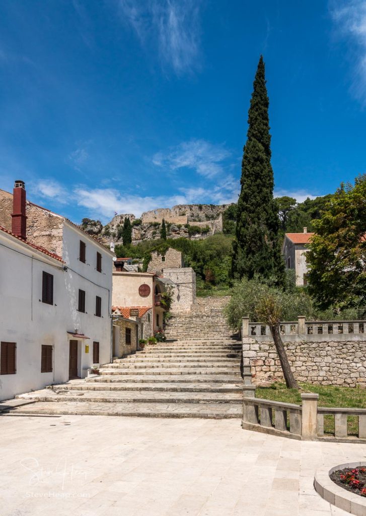 Church and square with fortress on hilltop in the coastal town of Novigrad in Croatia