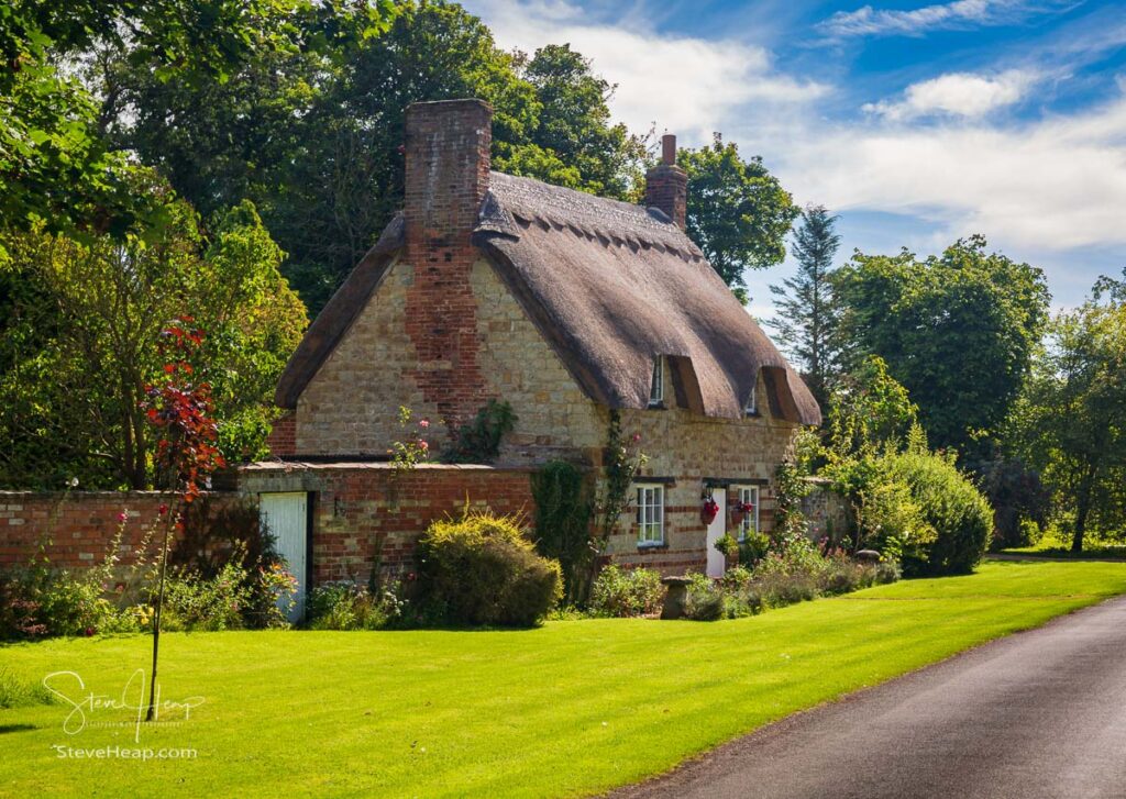 Small, thatched cottage built with cotswold stone with flower garden in the village of Honington. Prints in my store