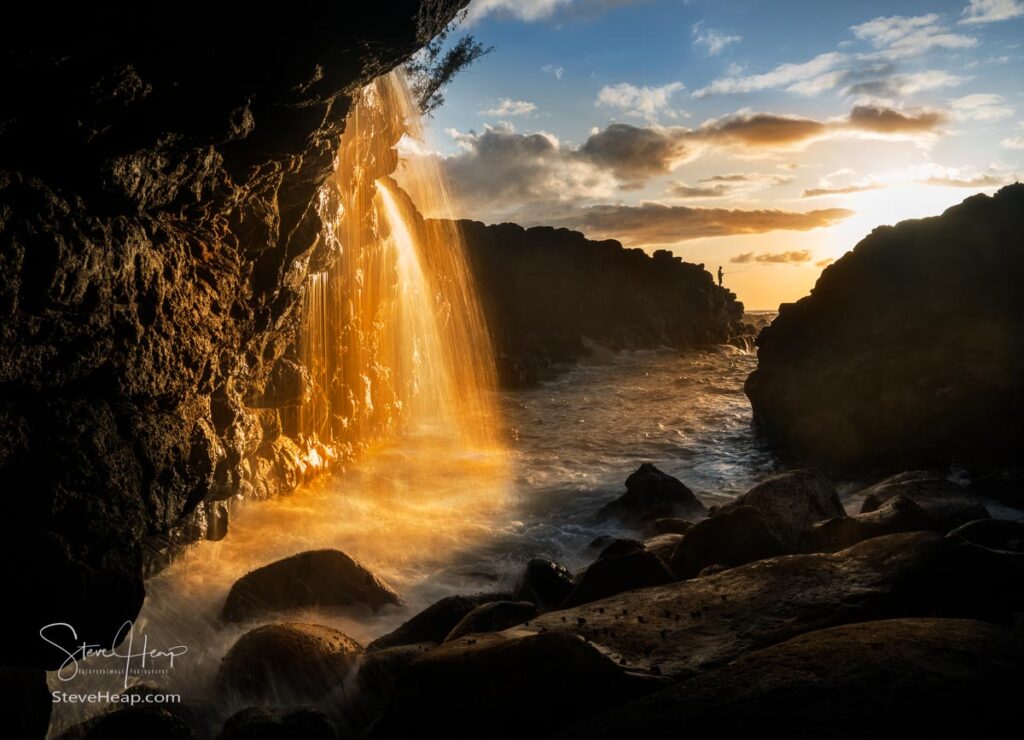 Setting sun at sunset illuminates a small waterfall falling into the ocean as a local fisherman waits for a bite. Prints available in my online store