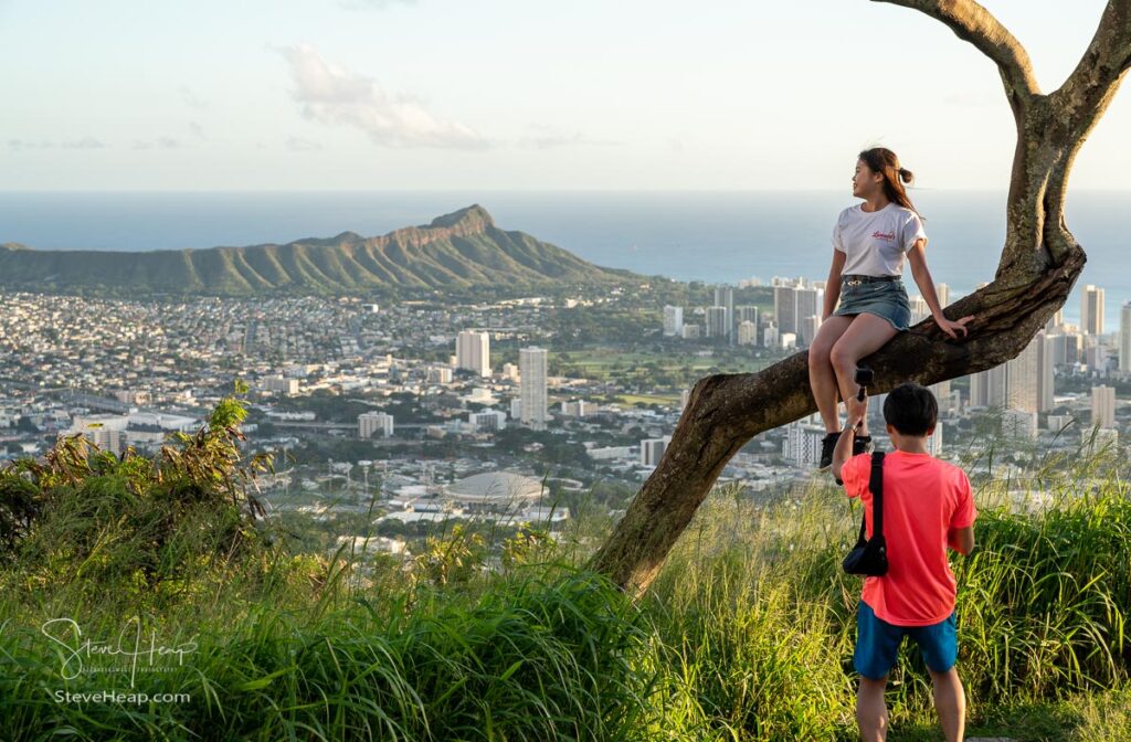Honolulu, HI - 25 January 2020: Tourists pose for photos at Tantalus Overlook with Waikiki and Diamond Head in background