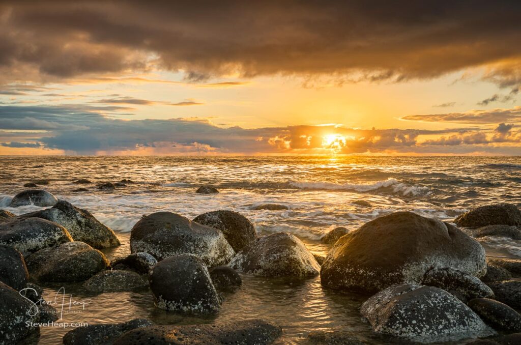 Sun setting over the Pacific ocean with eroded rocks on Ke'e Beach on north of Kauai, Hawaii. Prints available in my online store