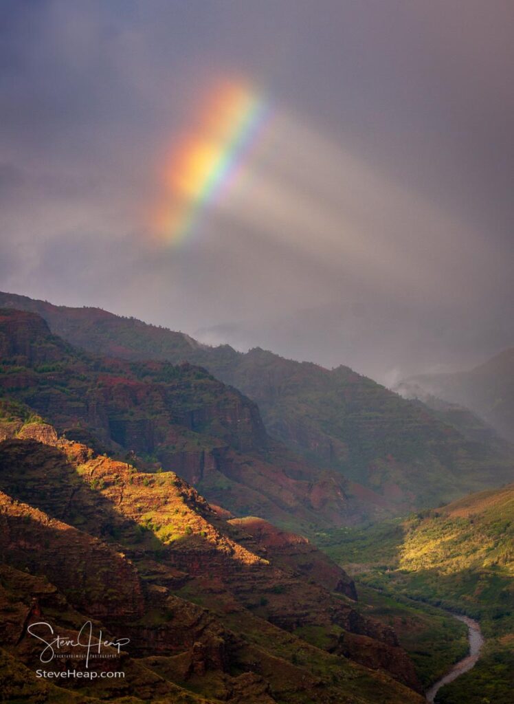 A dramatic rainbow peeps through the storm clouds over Waimea Canyon on the Hawaiian island of Kauai. 