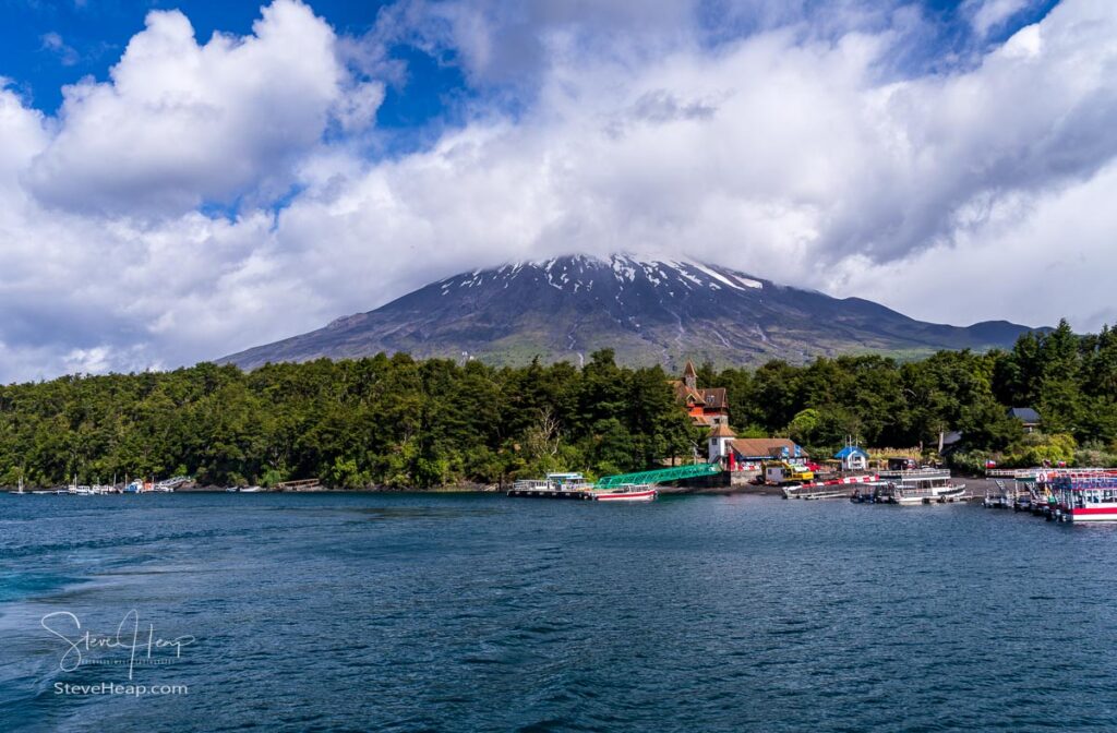 Boats docked at Petrohue harbor on the Todos Los Santos lake in Chile with the Osorno volcano in the background