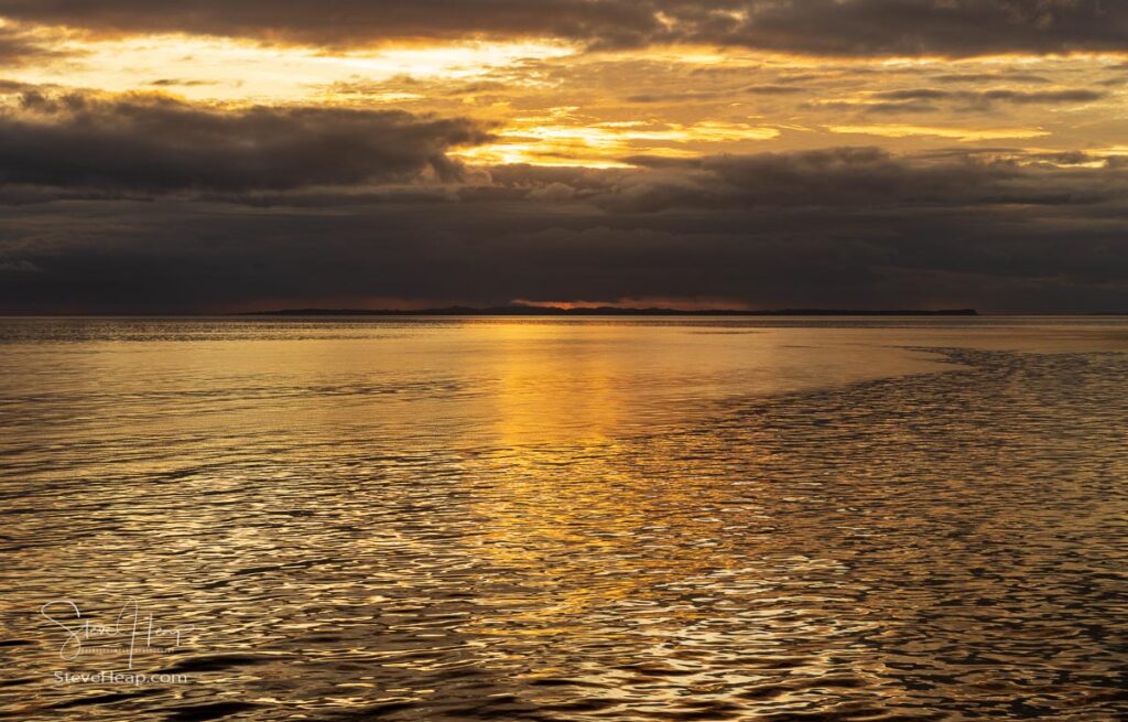 Golden sunset above a mirror like surface of the Pacific Ocean