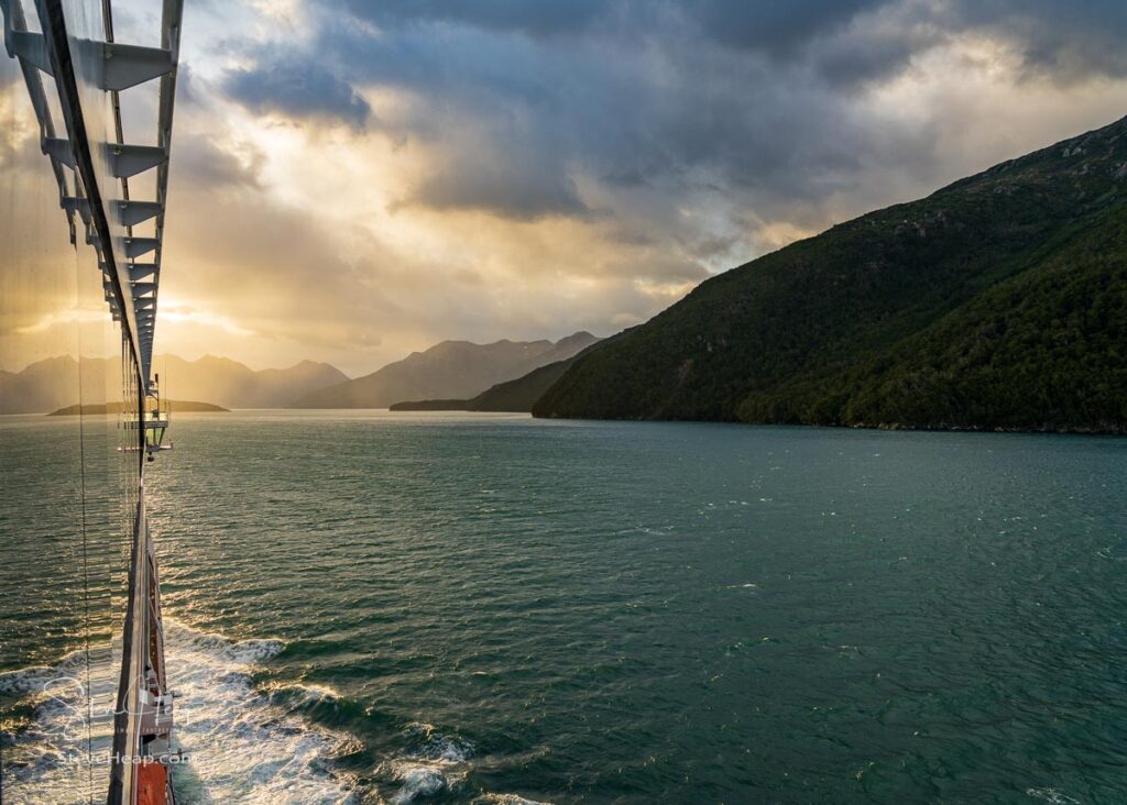 Reflections in windows of cruise ship sailing between mountains in Glacier Alley of Beagle channel