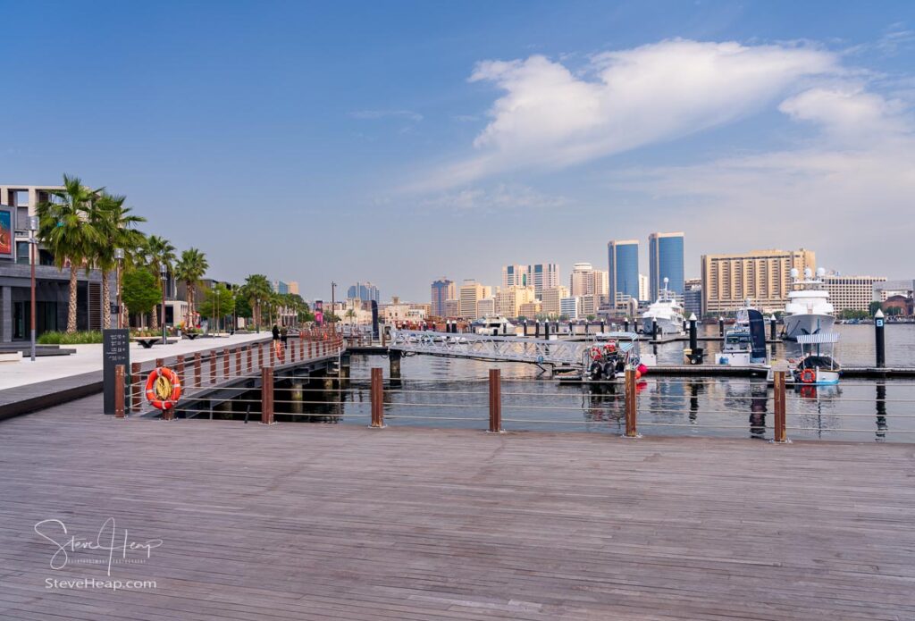 View along the Creek towards Deira with large boats docked by the Al Seef boardwalk in Dubai, UAE. Prints in my online store