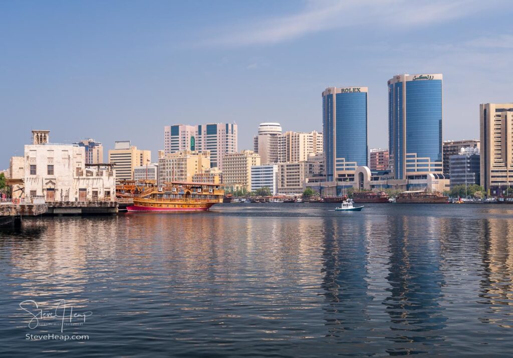 Dubai, UAE - 31 March 2023: View along the Creek towards Deira with large dhow tour boats docked by the Al Seef boardwalk