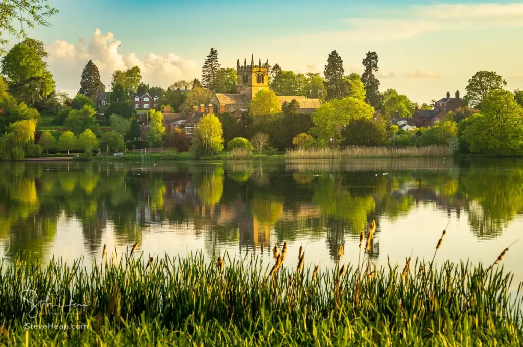 Ellesmere framed by the rushes on the far bank of the Mere on a calm evening