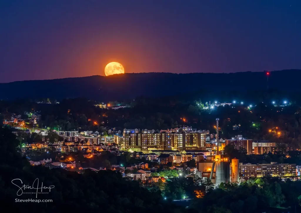 The almost blue moon rises over the student housing and WVU Power station in Morgantown WV. 