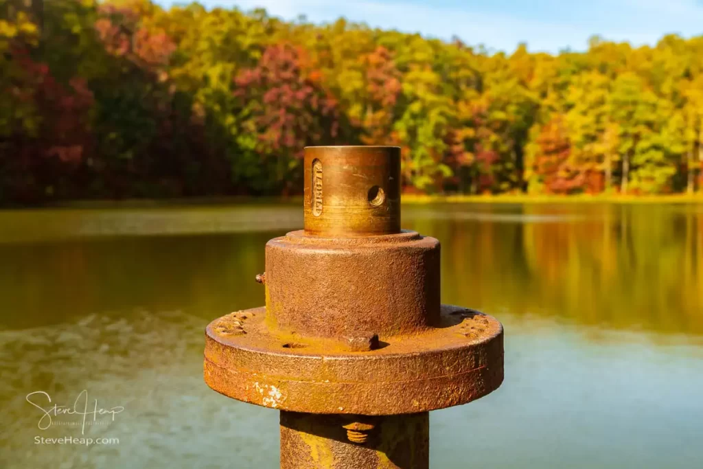 Rusty iron pipe or control valve with the fall trees in the background at Coopers Rock reservoir. Prints can be purchased here in my store