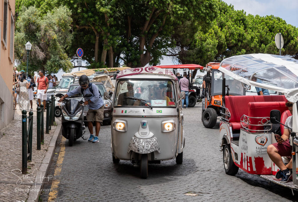 Tuk Tuk rickshaws wait for customers at a Miradouro in the Alfama district