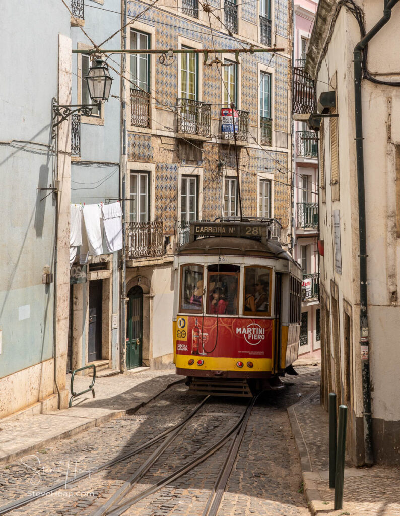 Tram in narrow streets of Alfama district of Lisbon on famous route 28