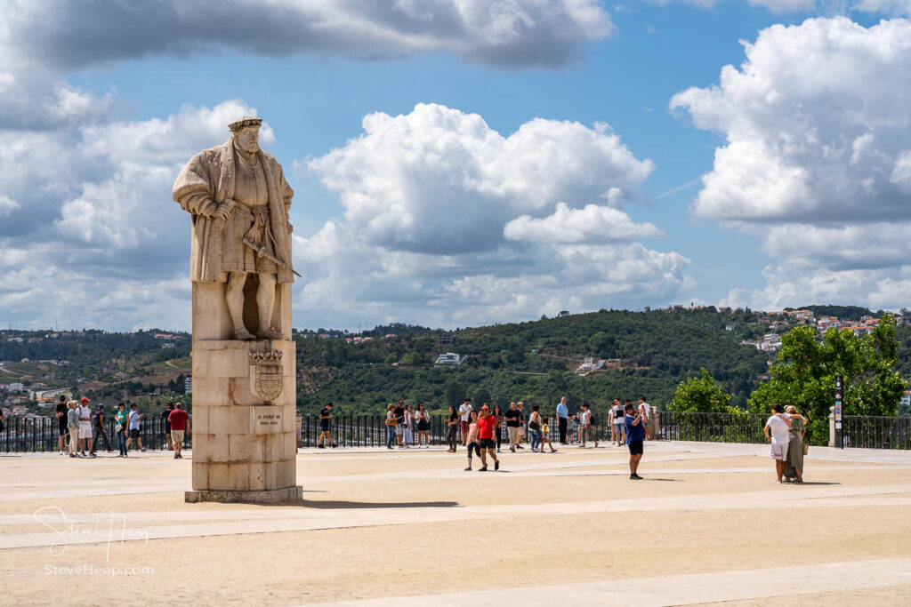 Tourists visiting the main square with statue of King Joao of the University of Coimbra in Portugal