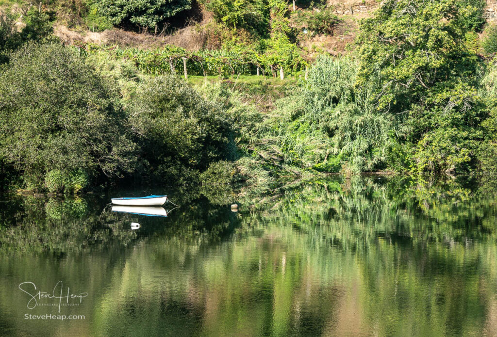 Fishing or rowing boat anchored in the calm waters on the bank of the River Douro in Portugal