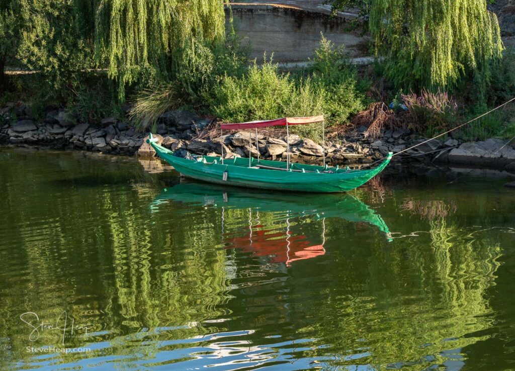 Fishing or rowing boat anchored in the calm waters on the bank of the River Douro in Portugal