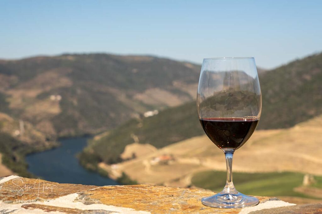 Glass of red wine for tasting above the hillsides of the Douro valley in Portugal