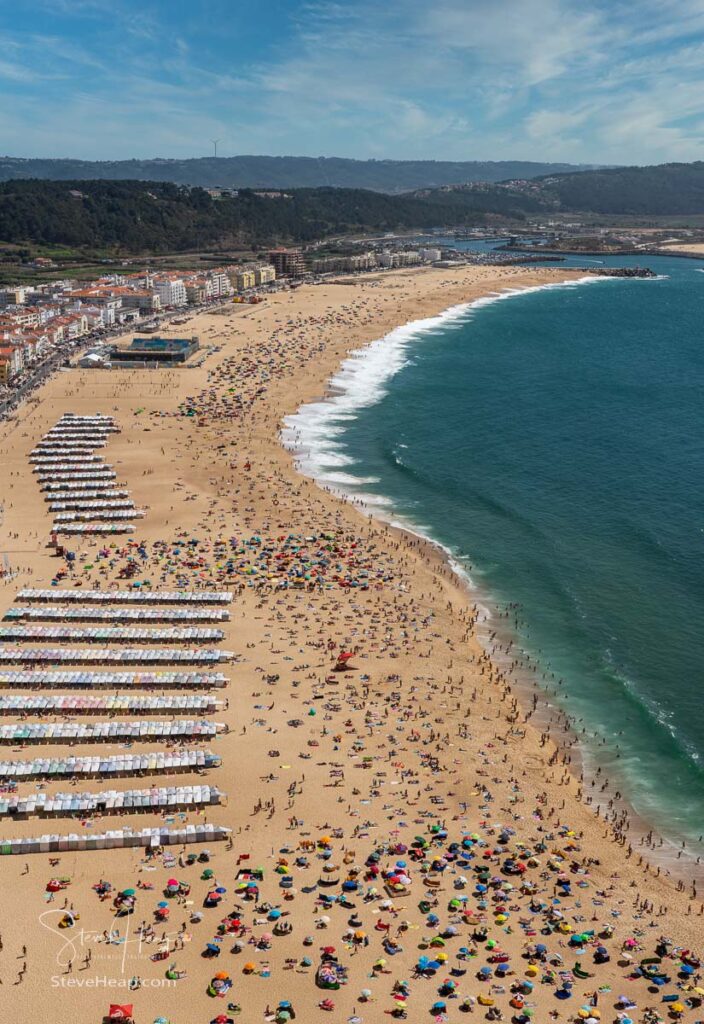Crowded beach of Nazare in Portugal from above with tourists relaxing on the sand