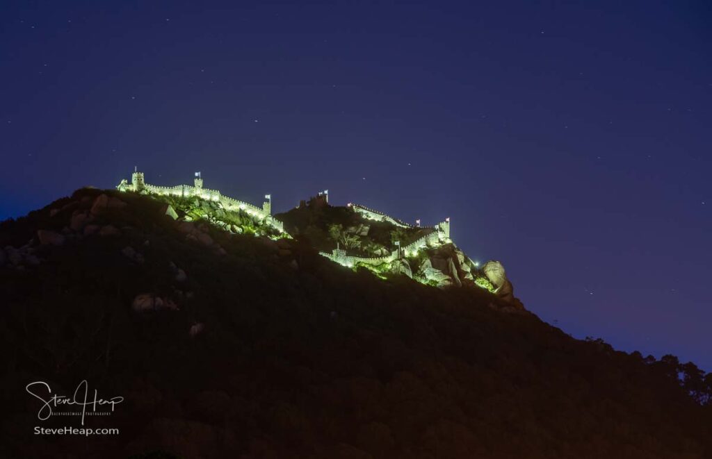 Evening view of the Moorish fortress on the hilltop above the city of Sintra illuminated at night