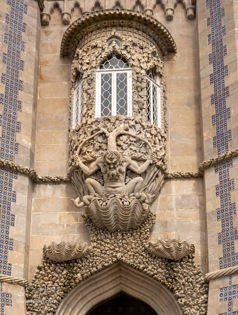 Arch of Triton over the entrance to the dramatic towers of Pena Palace above the town of Sintra