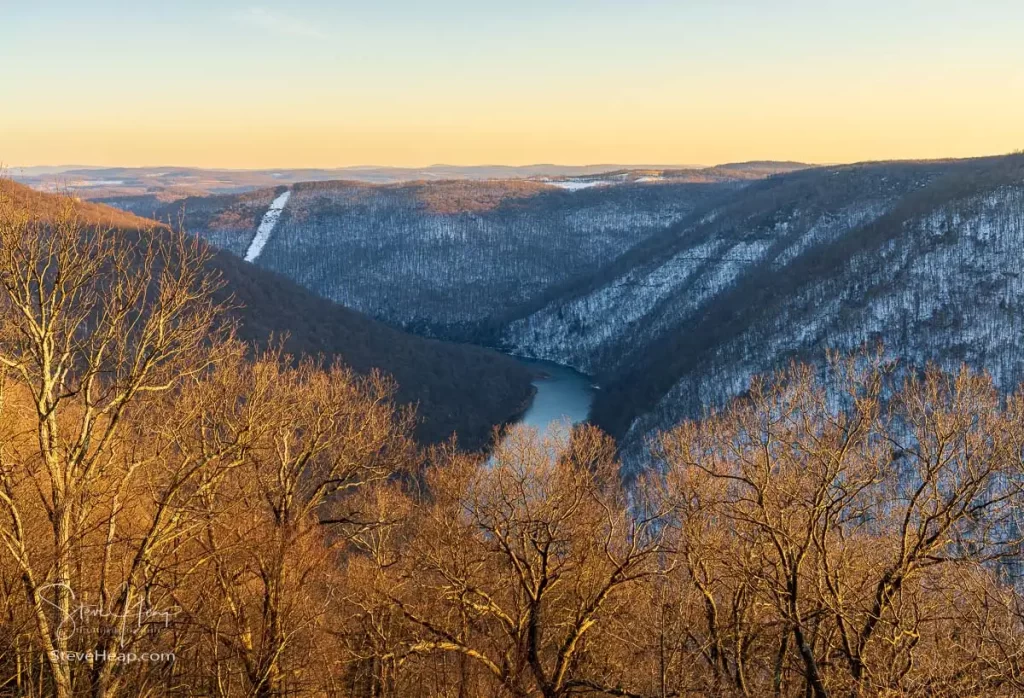 Warm sunlight on the bare branches of the trees contrasts with the cold snow-covered Cheat River gorge. Prints available in my online store