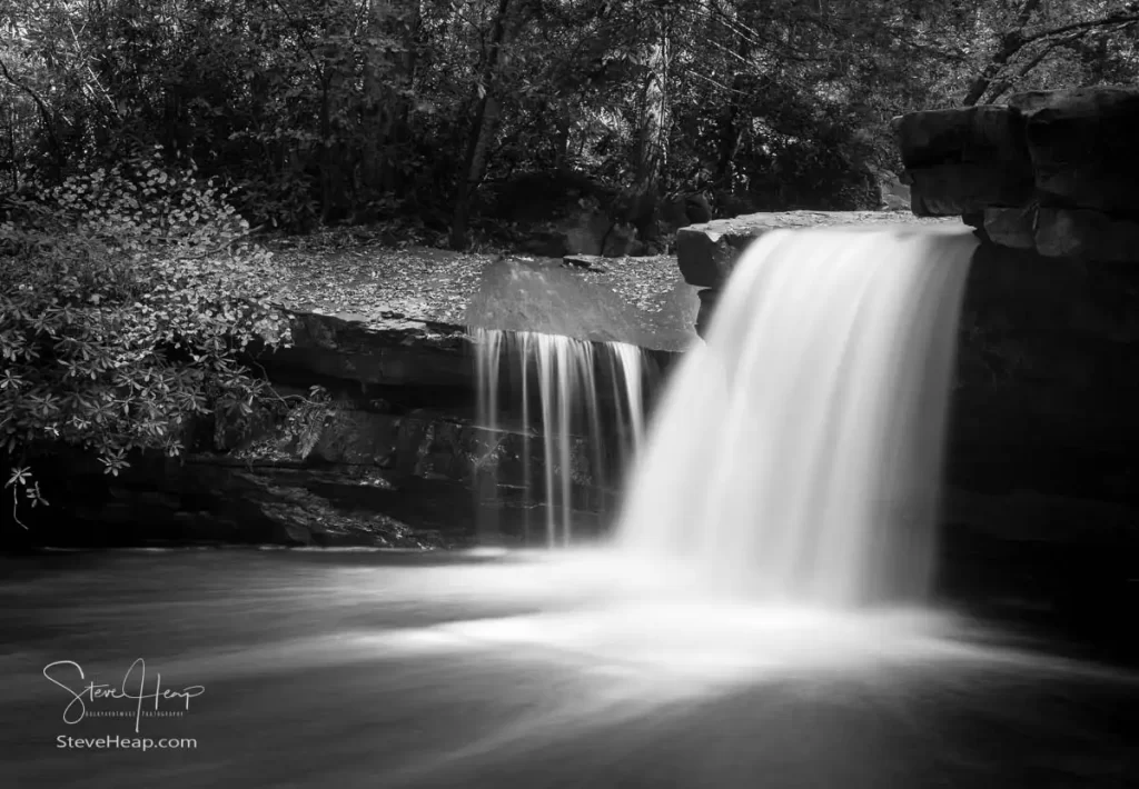 Black and white version of a cascade of waterfall into swimming hole with blurred motion on Deckers Creek running by Route 7 near Masontown in Preston County West Virginia
