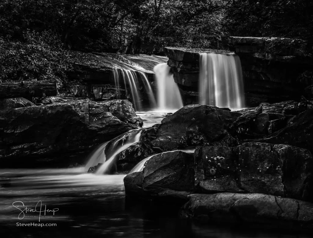 Black and White treatment of a cascade of waterfall into swimming hole with blurred motion on Deckers Creek running by Route 7 near Masontown in Preston County West Virginia