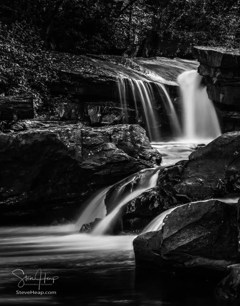 Black and White treatment of a cascade of waterfall into swimming hole with blurred motion on Deckers Creek running by Route 7 near Masontown in Preston County West Virginia