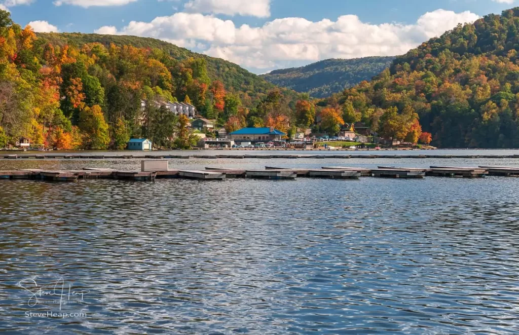 Empty boat docks in marina on Cheat Lake near Morgantown West Virginia with beautiful fall colors on the trees