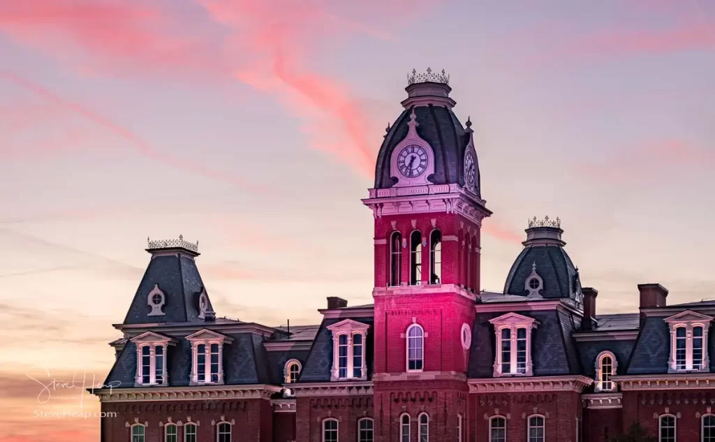 Dramatic image of Woodburn Hall at West Virginia University or WVU in Morgantown WV as the sun sets behind the illuminated historic building