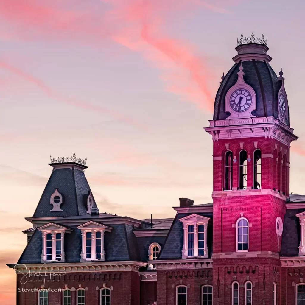 Dramatic image of Woodburn Hall at West Virginia University or WVU in Morgantown WV as the sun sets behind the illuminated historic building