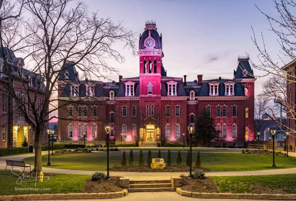 Dramatic image of Woodburn Hall at West Virginia University or WVU in Morgantown WV as the sun sets behind the illuminated historic building