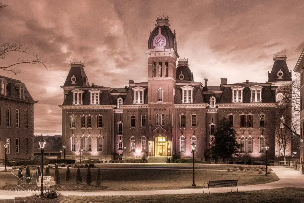 Dramatic sepia image of Woodburn Hall at West Virginia University or WVU in Morgantown WV as the sun sets behind the illuminated historic building