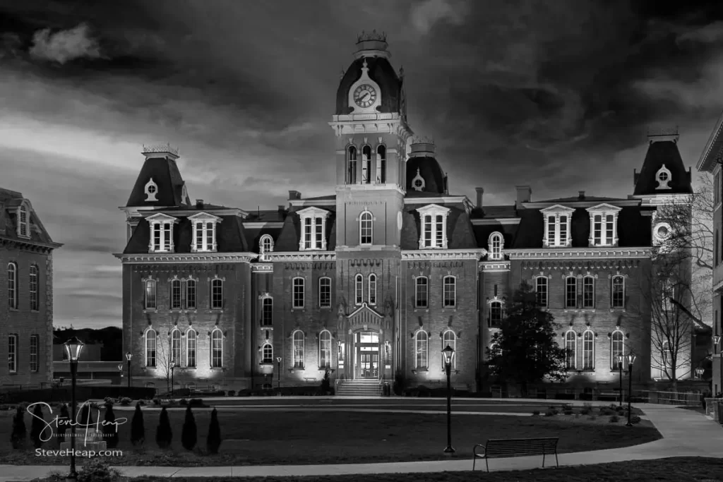 Dramatic black and white monochrome image of Woodburn Hall at West Virginia University or WVU in Morgantown WV as the sun sets behind the illuminated historic building. Perfect for a graduation gift for a student or for the wall of a faculty office