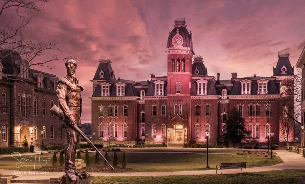 Discover the timeless allure of West Virginia University's iconic Woodburn Circle at sunset. This breathtaking panorama converted to an antique sepia finish, featuring the stately Woodburn Hall and Martin Hall, epitomizes the essence of academia, heritage, and the serenity of winter's touch. The famous Mountaineer statue has been transposed from its normal position across the street from this view to add some digital magic to the scene and incorporate one of WVU's icons into an equally iconic location at the University.